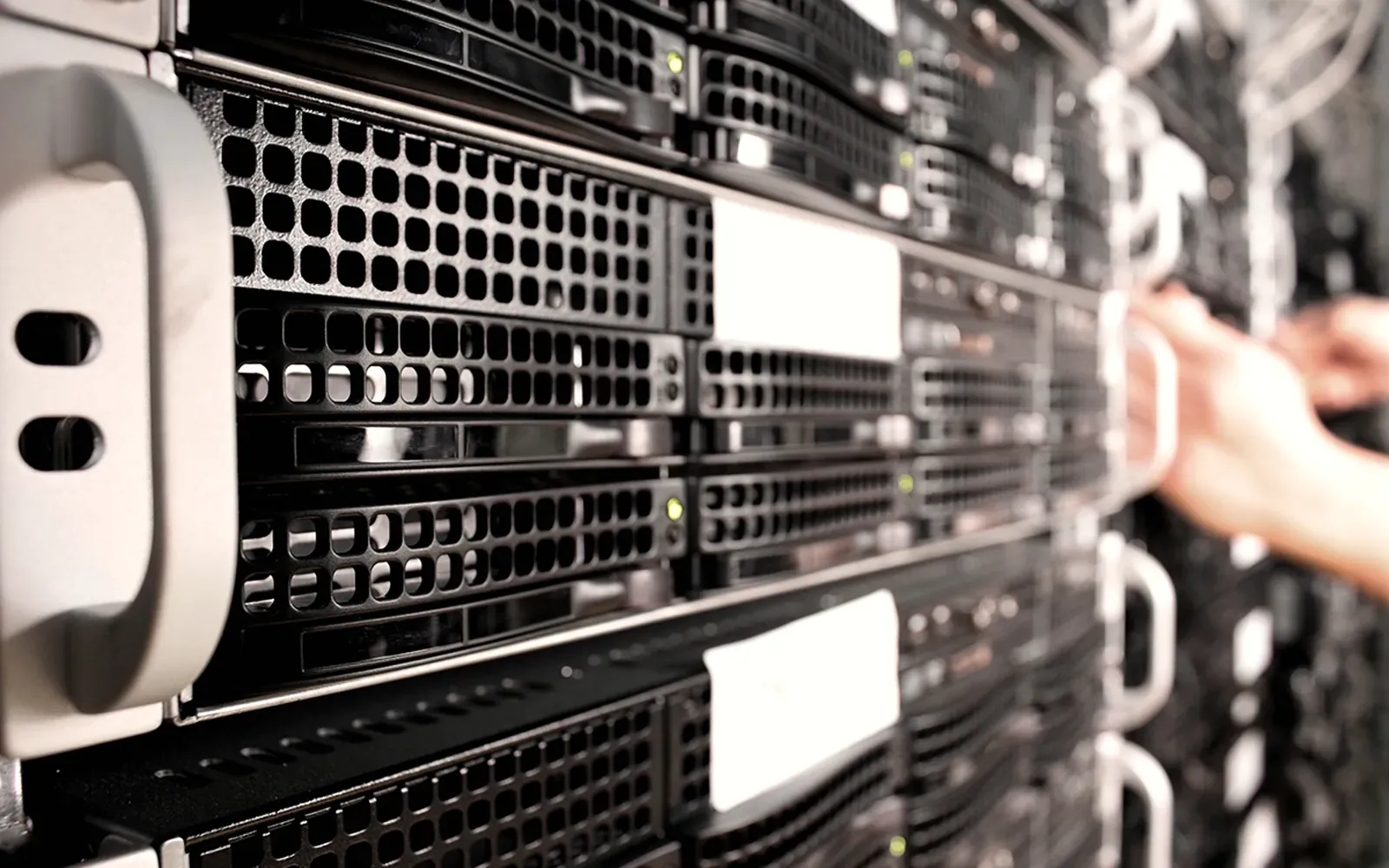 Técnico manipulando el frontal de un rack de servidores en una sala técnica